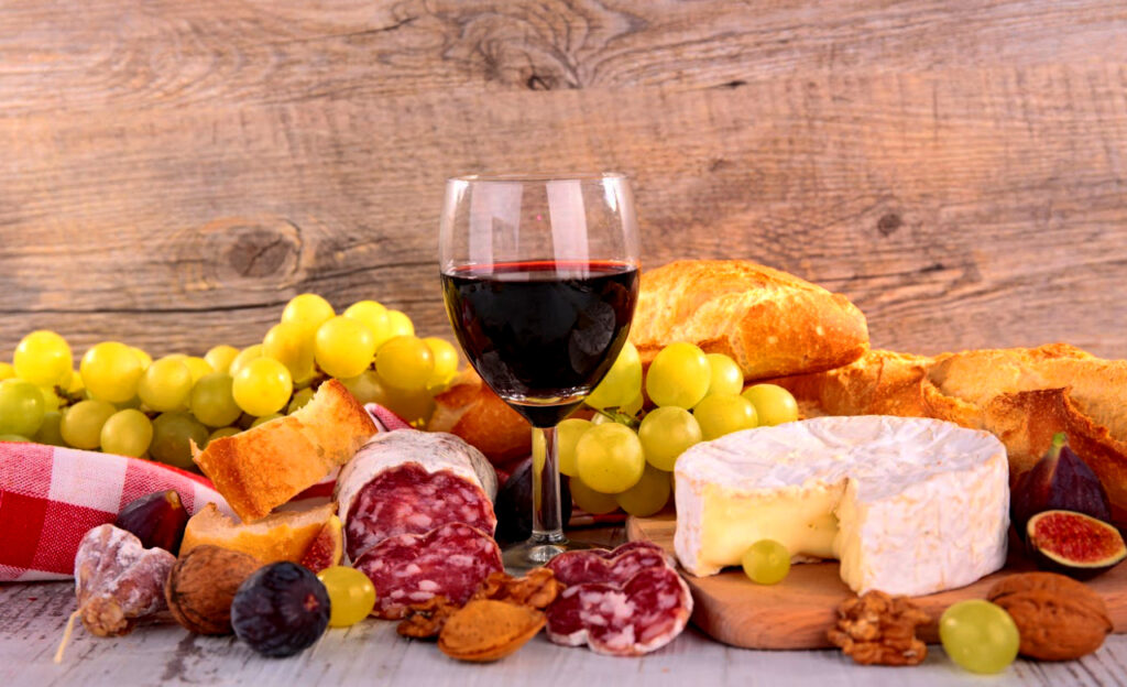 a glass of red wine and various foods